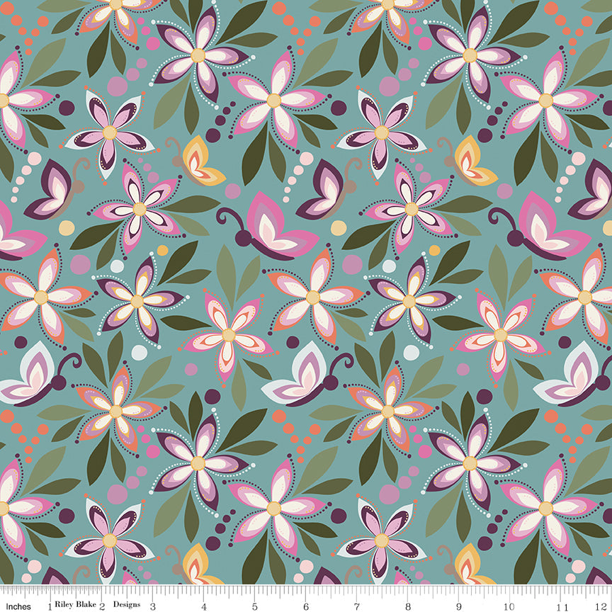 Juju's Petals Floral Teal quilting fabric shown with a ruler for scale, featuring large colorful flowers, whimsical butterflies, and green leaves on a muted teal background.