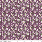 Juju's Petals Dance Purple floral quilting fabric shown with a ruler for scale, featuring cream and pink daisies with green foliage on a purple background.