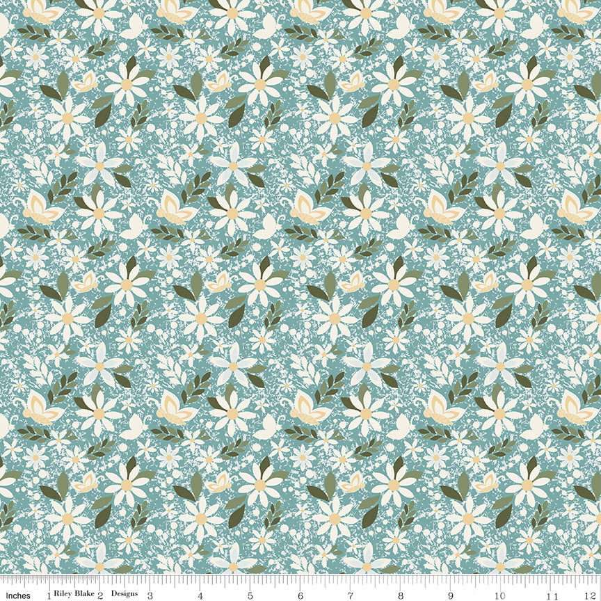 Juju's Petals Dance Teal floral quilting fabric shown with a ruler for scale, featuring cream daisies and green foliage on a teal background.