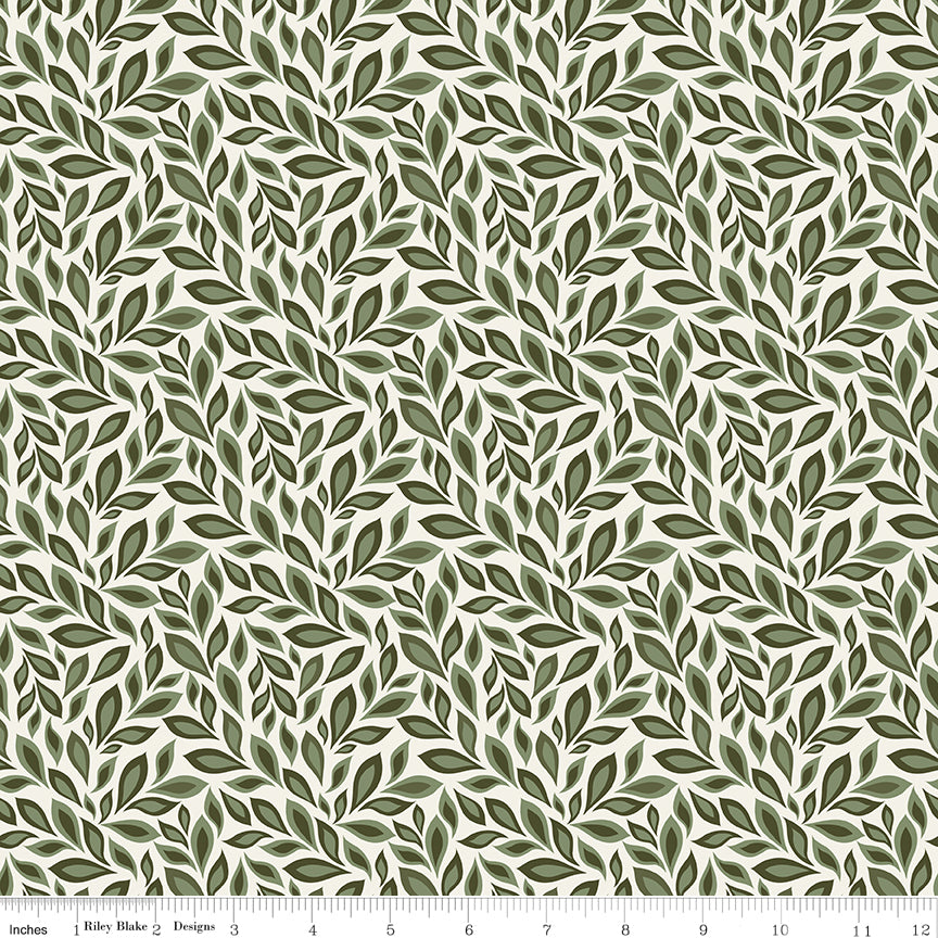 Juju's Petals Leaves Cream botanical quilting fabric shown with a ruler for scale, featuring overlapping green leafy branches on a light cream background.