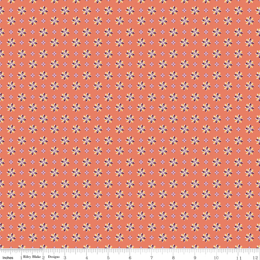 Juju's Petals Calico Orange floral fabric shown with a ruler for scale, featuring rows of colorful small flowers on a coral-orange background.