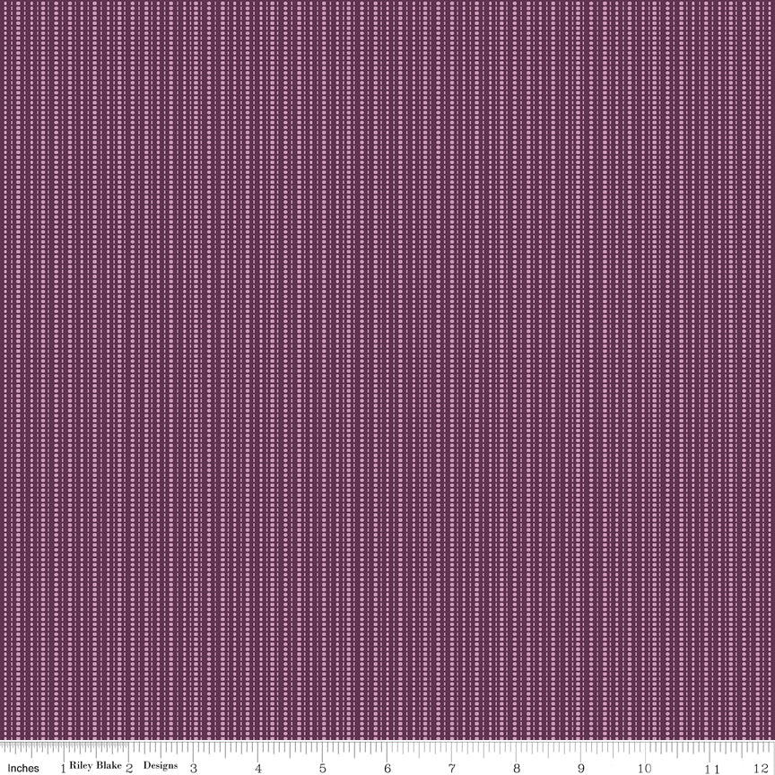 Juju's Petals Dotted Stripe Purple fabric shown with a ruler for scale, featuring narrow vertical rows of lavender-pink dots and dashes.