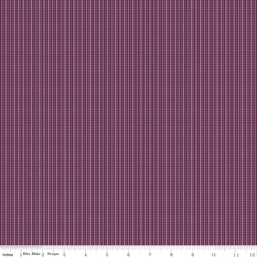 Juju's Petals Dotted Stripe Purple fabric shown with a ruler for scale, featuring narrow vertical rows of lavender-pink dots and dashes.